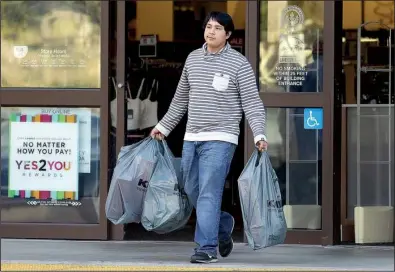  ?? AP/BEN MARGOT ?? A shopper exits a department store in Alameda, Calif., a week ago. Consumer spending rose 0.3 percent in November, the Commerce Department said Wednesday.