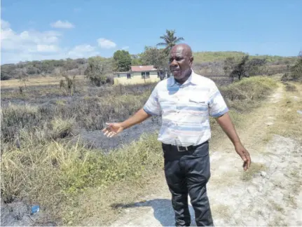  ??  ?? Mayor of Falmouth Councillor C Junior Gager on a tour of the farm in Georgia, Trelawny, where a bush fire destroyed a fire truck on Thursday.