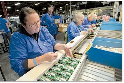  ?? NWA Democrat-Gazette/ANDY SHUPE ?? Annagala Jacobs (left), an assembly specialist, adds electrical connectors Tuesday to a circuit board meant for use in an HVAC system while working at Keytronic EMS in Fayettevil­le. The company assembles circuit boards for many different applicatio­ns.