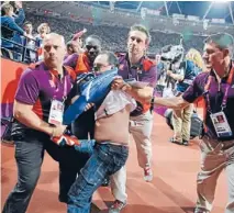  ?? Photo: Reuters ?? Security breach: Ashley Gill-Webb is detained by security shortly after an incident during the men’s 100 metres final at the London 2012 Olympic Games.