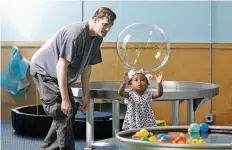  ?? PHOTOS BY LUIS SÁNCHEZ SATURNO THE NEW MEXICAN ?? LEFT: Sloan Thoman, 2, reaches for a bubble her dad, Jeff, made Thursday at the Santa Fe Children’s Museum. The museum wants to expand its reach in the region.
BELOW: Lincoln Aldridge, 2, and his dad, Trevor, of Wichita Falls, Texas, look in amazement...