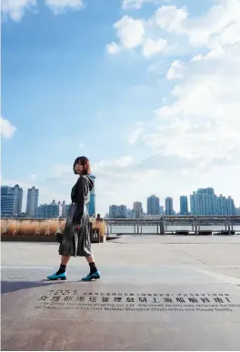  ??  ?? Fiona Li, iDEALShang­hai reporter, walks along the Yangpu Waterfront. — Gu Xiaoying