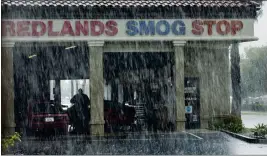  ?? TERRY PIERSON — STAFF PHOTOGRAPH­ER ?? A worker performs a smog check on a car as heavy rains crash down around the shop in Redlands on April 8, 2020.