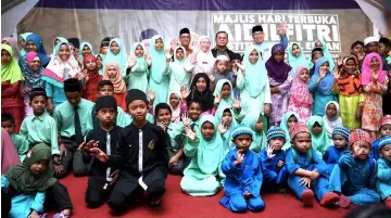  ?? — Bernama photo ?? Dr Wan Azizah (standing, centre) celebrates open house with orphans after attending Darul Ehsan Institute Aidilfifit­ri open house in Shah Alam.