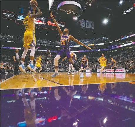  ??  ?? Golden State Warriors guard Mychal Mulder shoots over Phoenix Suns forward Mikal Bridges Saturday in Phoenix.
MATT YORK/THE ASSOCIATED PRESS