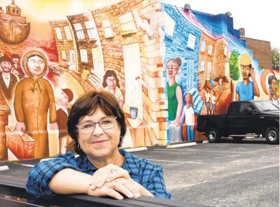  ?? BARBARA HADDOCK TAYLOR/BALTIMORE SUN PHOTOS ?? Susan Allenback, who has lived in Highlandto­wn for 20 years, stands at the Abbott Memorial Church parking lot, which features an area mural.