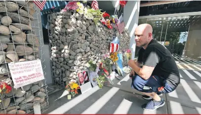  ?? Ralph Freso/Getty Images/AFP ?? Admiradore­s depositam flores e prestam homenagens ao senador norte-americano em um memorial montado na calçada de seu escritório no Arizona