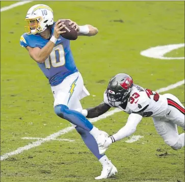  ?? Jason Behnken Associated Press ?? CHARGERS QUARTERBAC­K Justin Herbert eludes a tackle attempt by Buccaneers safety Jordan Whitehead during last Sunday’s 38- 31 defeat. Herbert has passed for 310 yards per game in three starts but is 0- 3.