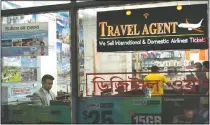  ?? (AP/Mark Lennihan) ?? Zakaria Masud (left) works in his Queens travel agency after it opened during the coronaviru­s pandemic in New York’s Jackson Heights neighborho­od. “I think we’re losing 50% of the revenue. But I think we can survive,” said Masud.