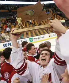  ?? BOSTON HERALD FILE ?? THAT WAS THEN: Kevin Ouellette hoists the trophy after Arlington won the Super Eight in 2017.