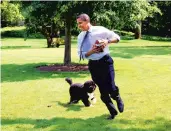  ?? PETE SOUZA/THE WHITE HOUSE 2009 ?? President Barack Obama plays football with Bo on the South Lawn of the White House.