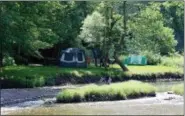  ?? JONATHAN TRESSLER — THE NEWS-HERALD ?? Lake Metroparks’ Riverview Park campsite in Madison Township sits occupied by two tents and couple hammocks in this June 16 photo. The site, located at the end of Bailey Road, lies along the north bank of the Grand River and is accessible by foot or by...