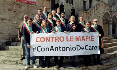  ?? ?? A Perugia Lo striscione di solidariet­à a Decaro sorretto ieri dai sindaci prima della cerimonia per i 50 anni dell’anci dell’umbria