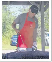  ??  ?? SUEANN MUSICK/THE NEWS Frank MacLeod sprays a special sauce on the pork chops grilling during the Scotsburn Fire Department’s barbecue. The same recipe for the sauce has been used for 50 years on the chops.