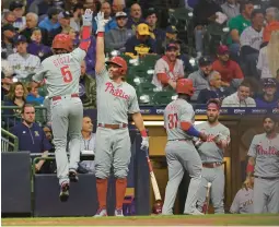  ?? STACY REVERE/GETTY ?? The Phillies’ Bryson Stott celebrates with teammate Rhys Hoskins after hitting a two-run home run against the Brewers on Wednesday in Milwaukee.