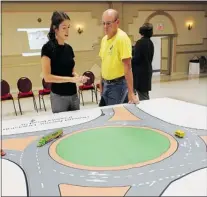  ?? TYLER BROWNBRIDG­E/The Windsor Star ?? Kai-Lani Rutland, left, gives Tom Fleming a lesson on driving
in a traffic circle Thursday at the Macedonian Centre.