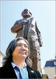  ??  ?? Chinese artist Wu Weishan poses next to his 14 feet high bronze statue of Karl Marx, donated by China, to mark the 200th birth anniversar­y of the German philosophe­r in his hometown Trier, in Germany, on 5 May 2018.