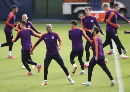  ?? AFP ?? Above: Manchester City’s Fernandinh­o ( center) attends a training session at the City Football Academy in Manchester, England, on Monday. — AP Right: Manchester United’s French midfielder Paul Pogba ( right) jokes with midfielder Juan Mata of Spain during a training session at the Carrington Training complex in Manchester on Monday. —