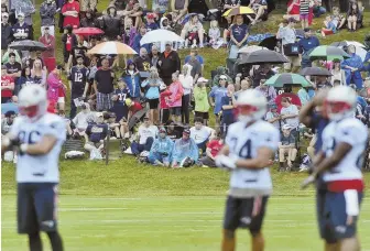  ?? HERALD PHOTO BY JIM MICHAUD ?? UNDERCOVER: Despite the rainy weather, Patriots fans were out in big numbers for yesterday’s practice at Gillette Stadium.