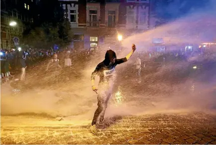  ?? PHOTOS: REUTERS ?? A police water cannon sprays a protester during the demonstrat­ions against the G20 summit in Hamburg.