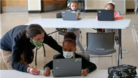  ?? MATT STONE / HERALD STAFF FILE ?? EXTRA HELP: Yaline Cardoso-Barreto 8, gets help from Maggie Mattaini, program administra­tor for the YMCA, on her school work at the YMCA on Sept. 21 in Roxbury. A recent Pioneer Institute poll showed many parents have been disappoint­ed in the level of education their kids received during the pandemic.