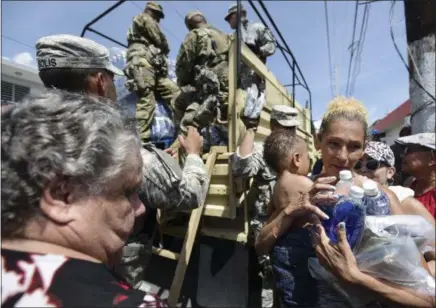  ?? CARLOS GIUSTI — THE ASSOCIATED PRESS ?? National Guardsmen arrive at Barrio Obrero in Santurce to distribute water and food among those affected by the passage of Hurricane Maria, in San Juan, Puerto Rico, Sunday. Federal aid is racing to stem a growing humanitari­an crisis in towns left...