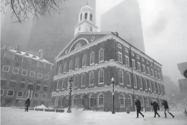  ?? Associated Press ?? n People walk past Boston’s Faneuil Hall—named after Peter Faneuil, a successful merchant and trader whose ships carried slaves between continents as well as the normal dry goods, spices and wares. The national soul-searching over discrimina­tory...