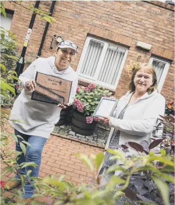  ??  ?? Last year’s Gentoo community garden winners at Ayton Gardens with their award.