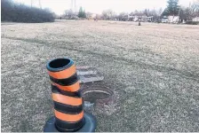  ?? JACK LAKEY PHOTO ?? This utility chamber, in the hydro corridor near the intersecti­on of Willowdale and Bishop avenues, was left uncovered for at least two years, with a city road pylon to mark the spot.