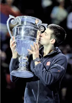  ?? — AFP photo ?? Serbia’s Novak Djokovic kisses the ATP World No 1 Award trophy after it was presented to him following his Group A singles match win against Czech Republic’s Tomas Berdych on day six of the ATP World Tour Finals tennis tournament in London on November...