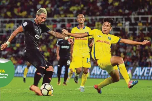  ?? FOTO: ?? PEMAIN Terengganu FC, Bruno Suzuki (kiri) membuat rembatan ke gawang sambil diasak pemain Pahang, Muhammad Ashar Al Aafiz.