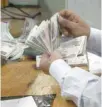  ?? — Reuters ?? An employee counts money at a bank in Cairo