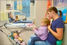  ??  ?? Colton, background, waits Nov. 16 for the dentist at the Children’s Dentistry of Gales Ferry as Kelsey sits with her daughter, Hadley, and Charlotte, 1, the daughter of Jessica Whitman and her husband, Jacob, who is deployed on the USS Minnesota with...