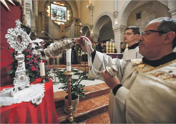  ?? AFP ?? Clockwise from top, a Catholic clergyman at the Church of the Nativity; Franciscan friars carry a small piece of the Relic of the Holy Crib of the Child Jesus to the Church of St Saviour; a nun and Palestinia­n children at a parade held to welcome the sacred artefact’s return to Bethlehem