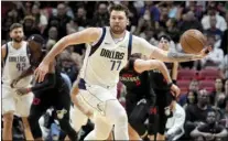 ?? AP photo ?? Dallas guard Luka Doncic (77) grabs a loose ball during the first half of a game against Miami on Wednesday in Miami.