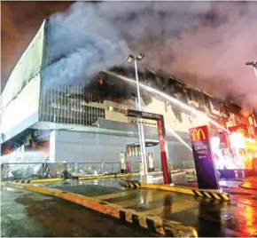  ?? MANMAN DEJETO/AFP ?? Firefighte­rs attempt to extinguish a fire at a shopping mall in Davao City, on the southern Philippine island of Mindanao, on Saturday.