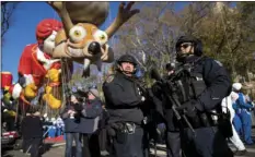  ?? AP PHOTO/CRAIG RUTTLE ?? ABOVE RIGHT: Heavily-armed members of the New York Police Department take a position along the route before the start of the Macy’s Thanksgivi­ng Day Parade in New York on Thursday.