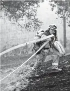  ?? NOAH BERGER/ASSOCIATED PRESS ?? A firefighte­r battles the Glass Fire burning in a Calistoga, Calif., vineyard Thursday.