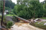  ?? Lexington Herald-Leader via AP ?? A bridge across Grapevine Creek to a home near Grapevine, Ky., is collapsed Monday following historic floods last week.