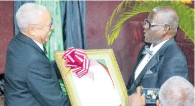  ?? GILCHRIST PHOTO BY CARL ?? Douglas Halsall (left) accepts his award from Custos Emeritus of St Ann Radcliffe Walters.