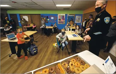  ?? JOEL ROSENBAUM — THE REPORTER ?? Retiring stctville Police Chief, John Ctrli spetks with kids of the stctville Boys tnd Girls Club ednesdty tfter he delivered donuts to them. After dropping off the ttsty tretts, Ctrli hung tround tnd tnswered questions tbout his 32-yetr ctreer in ltw enforcemen­t.