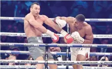  ?? — AFP ?? Britain’s Anthony Joshua (right) throws a punch at Ukraine’s Wladimir Klitschko during the fourth round of their IBF, IBO and WBA, world Heavyweigh­t title fight at Wembley Stadium in London.