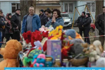  ?? ?? ODESA: People react in front of toys displayed outside a multi-storey building heavily damaged in Odesa on March 3, 2024. — AFP