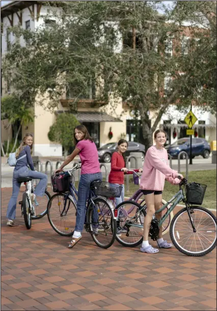  ?? ?? Young bicyclists in Ave Maria, Fla. Communitie­s certified as “blue zones,” a concept that promotes healthy living and longevity, are growing, but some wonder if the movement is just another gimmick.