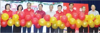  ??  ?? Lau (fourth left) with other YMCA board of directors pop the balloons to mark the opening of the event.