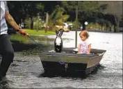  ?? LEMAY ACOSTA Carline Jean Associated Press ?? pulls his daughter and dog on a boat in f looded Plantation, Fla., on Monday.