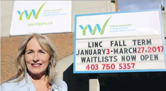  ?? LEAH HENNEL ?? Calgary YWCA CEO Sue Tomney with some of the signage developed as part of the organizati­on’s new visual brand identity.