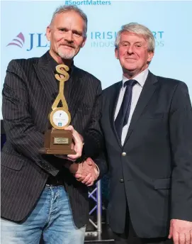  ??  ?? Vincent Hogan of the Irish Independen­t receives his Jimmy Magee Award for Sports Journalist of the Year with Roddy Guiney of the Federation of Irish Sports