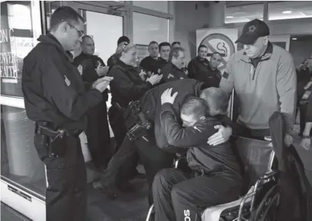  ??  ?? Officer Tony Lopez Jr. leaves Denver Health on Thursday to a round of applause and hugs fromother police officers. His father is behind him. Lopez said his wife is expecting and his goal is to walk his baby out of the hospital. Kenneth D. Lyons, The...
