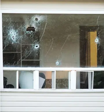  ?? ANDREW VAUGHAN / THE CANADIAN PRESS ?? Bullet holes riddle a window in an apartment building in Fredericto­n after a shooting spree last Friday that left four people dead, including two city police officers. Residents of the building began returning to their homes on Tuesday.